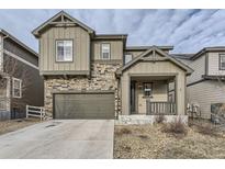 Charming two-story home featuring stone accents, a front porch, a two-car garage, and a well-maintained lawn at 2616 Loon Cir, Castle Rock, CO 80104