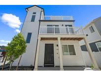 Stunning three-story home featuring a white exterior, balconies, and modern architectural details at 18211 E 51St Ave, Denver, CO 80249