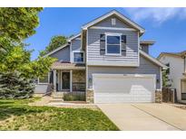 Charming two-story home featuring a stone facade, two-car garage, and well-manicured front lawn at 9890 Gaylord St, Thornton, CO 80229