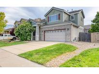 Charming two-story home with a well-manicured lawn, stone accents, and an attached two-car garage at 7345 S Nucla St, Aurora, CO 80016