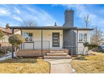 Charming home featuring brick accents, a covered porch, and well-maintained landscaping at 2800 Albion St, Denver, CO 80207