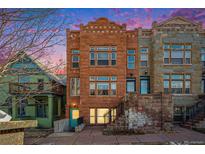 Three-story row house featuring red and gray stone facade with large windows and a stoop entrance at 1610 N Humboldt St # 1/2, Denver, CO 80218