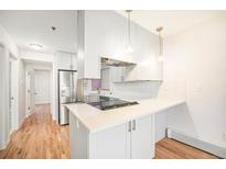 Bright, modern kitchen with stainless steel appliances, white cabinets, and hardwood floors at 1610 N Humboldt St # 1/2, Denver, CO 80218