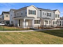 Attractive townhomes with a black metal fence and lush green lawn in a well-maintained community at 27492 E 1St Ave, Aurora, CO 80018