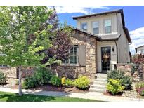 Charming two-story home featuring stone accents, a welcoming front porch, and beautiful landscaping at 15569 W La Salle Ave, Lakewood, CO 80228