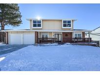 Two-story house with attached garage and snow-covered front yard at 10350 W Burgundy Ave, Littleton, CO 80127