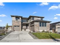 Two-story home with stone accents and a landscaped yard at 7125 S Yantley Way, Aurora, CO 80016