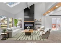Virtually staged living room featuring a fireplace and large windows at 8704 Garrison Ct, Arvada, CO 80005