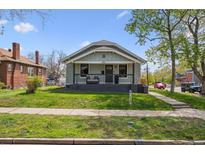 Charming home with a covered front porch and well-maintained lawn and garden and walkway at 4504 N Clay St, Denver, CO 80211