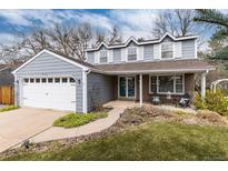 Charming two-story home with blue siding, white trim, and a well-manicured front yard at 7142 S Hudson Ln, Centennial, CO 80122