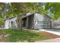 Modern gray home featuring a stylish garage door, manicured lawn and front yard landscaping at 2201 Juniper Ct, Boulder, CO 80304