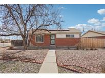 Charming brick home featuring a low-maintenance xeriscaped yard and solar panels on the roof at 7180 Zuni St, Denver, CO 80221
