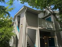 Charming condo exterior with wooden siding, bright blue accents, and staircase leading to the entrance at 8416 Pebble Creek Way # 203, Highlands Ranch, CO 80126