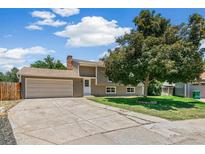 Charming home with a well-manicured lawn and a spacious driveway leading to a two-car garage on a sunny day at 8539 W Duquesne Dr, Lakewood, CO 80227