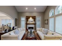 Bright living room featuring a fireplace, neutral walls, and white couches at 106 S University Blvd # 5, Denver, CO 80209