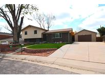 Charming two-story home with brick accents, a well-maintained lawn, and a detached garage with long driveway at 11823 Williams Way, Northglenn, CO 80233