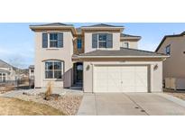 Inviting two-story home featuring neutral stucco, dark shutters, and a two-car attached garage at 2299 S Norse Way, Lakewood, CO 80228