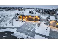 Beautiful single-Gathering home featuring a 2-car garage and charming covered porch, surrounded by a snowy landscape at 1060 Arrowhead Ct, Erie, CO 80516