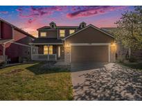 Charming two-story home with a spacious front yard and a two-car garage with stone details at 11748 Mill Valley St, Parker, CO 80138