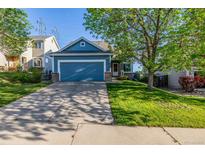 Charming blue home featuring a two-car garage and well-maintained lawn at 19884 E Villanova Pl, Aurora, CO 80013