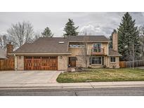 Charming two-story home featuring a brick facade, two car garage, and a quaint front yard at 7204 W Walden Dr, Littleton, CO 80128
