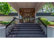 Building entrance with glass doors, stairs, and black railings offering easy access and a welcoming aesthetic at 2325 S Linden Ct # 206, Denver, CO 80222