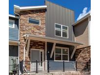 Contemporary townhouse exterior with a combination of stone, metal, and siding materials at 767 Robert St, Longmont, CO 80503