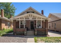Charming brick home featuring a cozy front porch with white support beams, showcasing classic architectural details at 4536 Beach Ct, Denver, CO 80211