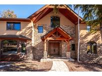 Stunning stone and wood exterior featuring a covered entryway and professionally designed facade at 7837 S Settlers Dr, Morrison, CO 80465