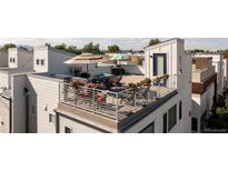 Relaxing rooftop patio with outdoor furniture, flowers, and an umbrella for shade at 4537 N Tennyson St # 101, Denver, CO 80212