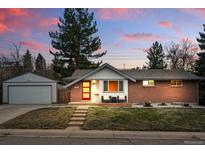 Charming brick home featuring a red door, landscaped front yard and detached garage at 2958 E Euclid Pl, Centennial, CO 80121