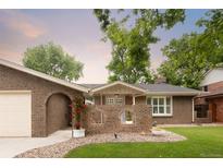 Charming brick home featuring a quaint front patio and lush, well-manicured lawn at 9861 E Ohio Ave, Denver, CO 80247