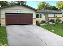 Charming single-story home with a well-manicured lawn, beautiful plants and a large driveway at 4665 E Peakview Ave, Centennial, CO 80121