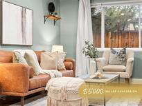 Inviting living room with a brown leather sofa, soft textures, and large window at 3555 Leyden St, Denver, CO 80207