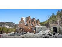 Charming three-story home showcasing its unique architecture and wintery surroundings at 6100 Bear Paw Rd, Golden, CO 80403