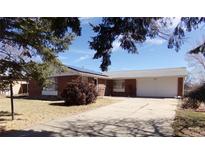 Charming brick home with an attached garage and a long driveway on a sunny day at 680 Kalmia Way, Broomfield, CO 80020
