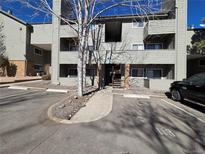 Multi-Gathering complex features covered entryways, assigned parking, and mature trees against a blue sky at 3100 S Federal Blvd # 213, Denver, CO 80236