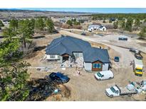 A beautiful home in progress, featuring a modern roof design and spacious construction site nestled in a scenic landscape at 1555 Arrowpoint Ct, Franktown, CO 80116