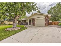 Ranch style home with attached garage and mature landscaping at 3004 S Ingalls Way, Denver, CO 80227