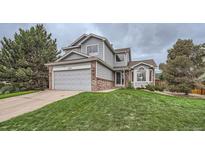 Charming two-story home with a well-manicured lawn, attached garage, and appealing curb appeal at 4567 Flanders Way, Denver, CO 80249