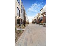 Modern townhomes line a street with landscaped sidewalks offering a desirable community setting at 9081 Westminster Blvd, Westminster, CO 80031