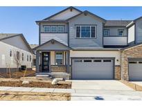 Charming two-story home with gray siding, stone accents, and an attached two-car garage at 6635 N Nepal St, Aurora, CO 80019