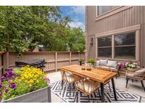 Cozy outdoor patio with wood table, seating, grill, and decorative rug and plants for perfect entertaining space at 1152 S Yosemite Way # 29, Denver, CO 80247