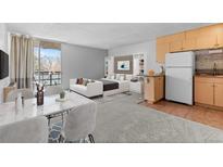 Bright, open living space featuring a bed, a dining area, and efficient kitchen with stainless steel appliances at 2500 S York St # 310, Denver, CO 80210