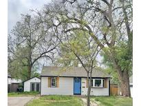 Charming single-story home with white siding, a bright blue front door, and mature trees in the front yard at 4745 S Sherman St, Englewood, CO 80113
