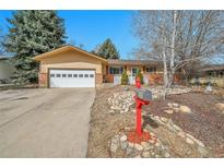 Ranch style home with a two-car garage and well-manicured landscaping, including decorative rocks and a red mailbox at 352 Indiana Ave, Berthoud, CO 80513