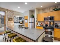 Modern kitchen with stainless steel appliances, bar seating, and an open layout to the bedroom at 801 Confidence Dr # 2, Longmont, CO 80504
