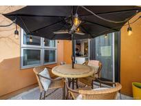 Cozy patio seating area with an umbrella, cafe lights and an outdoor heater at 801 Confidence Dr # 2, Longmont, CO 80504