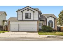 Charming two-story home with a two-car garage, manicured lawn, and beautiful architectural details at 3823 S Uravan St, Aurora, CO 80013
