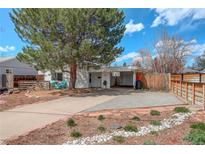 Charming single-story home featuring a large tree, covered parking, and well-maintained landscaping at 4521 E Jewell Ave, Denver, CO 80222